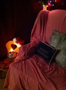 Red gingham sheets come off the kid's bed and cover several armchairs. Green pillow covers hide the blue toile for the Holiday Season. 