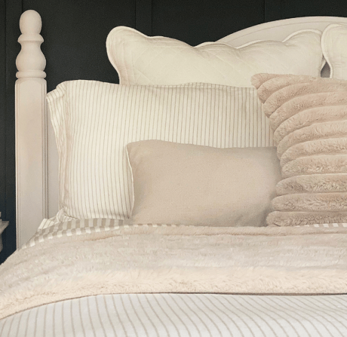 a bed with soft covers in beige for September scenes for decor